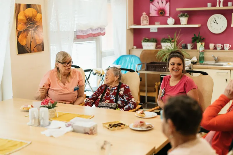 Residents and caregivers sharing a meal in a care community dining room